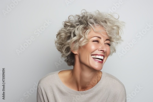 Closeup portrait of a beautiful happy middle aged woman with blonde curly hair