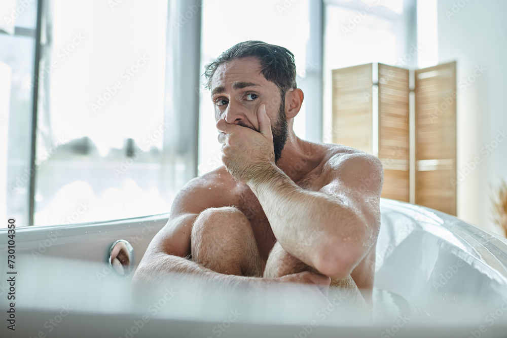 anxious man sitting in bathtub with hands near face during breakdown, mental health awareness anxious man sitting in bathtub with hands near face during breakdown, mental health awareness