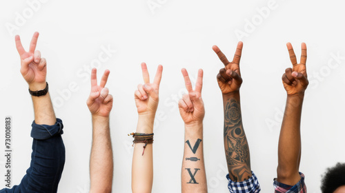 different arms raised against a white background, each making the peace sign with their fingers.