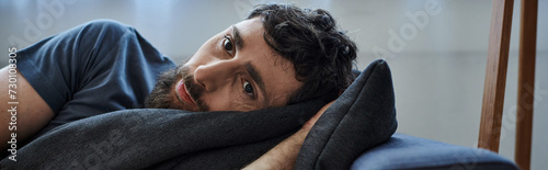 depressed man in casual outfit lying on sofa during breakdown, mental health awareness, banner photo
