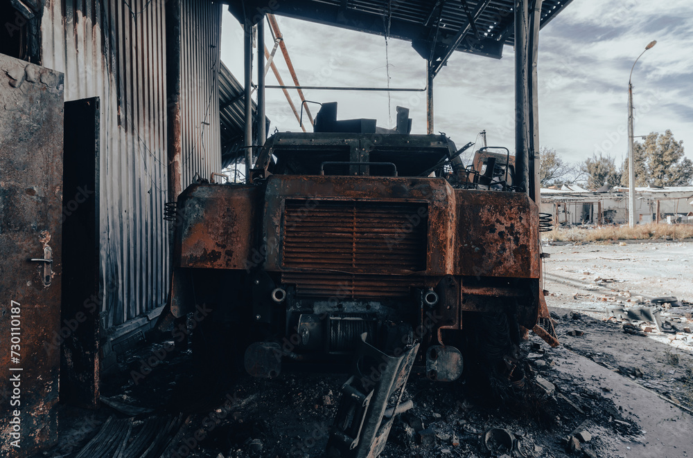 burnt military armored car on the street of the ruined city