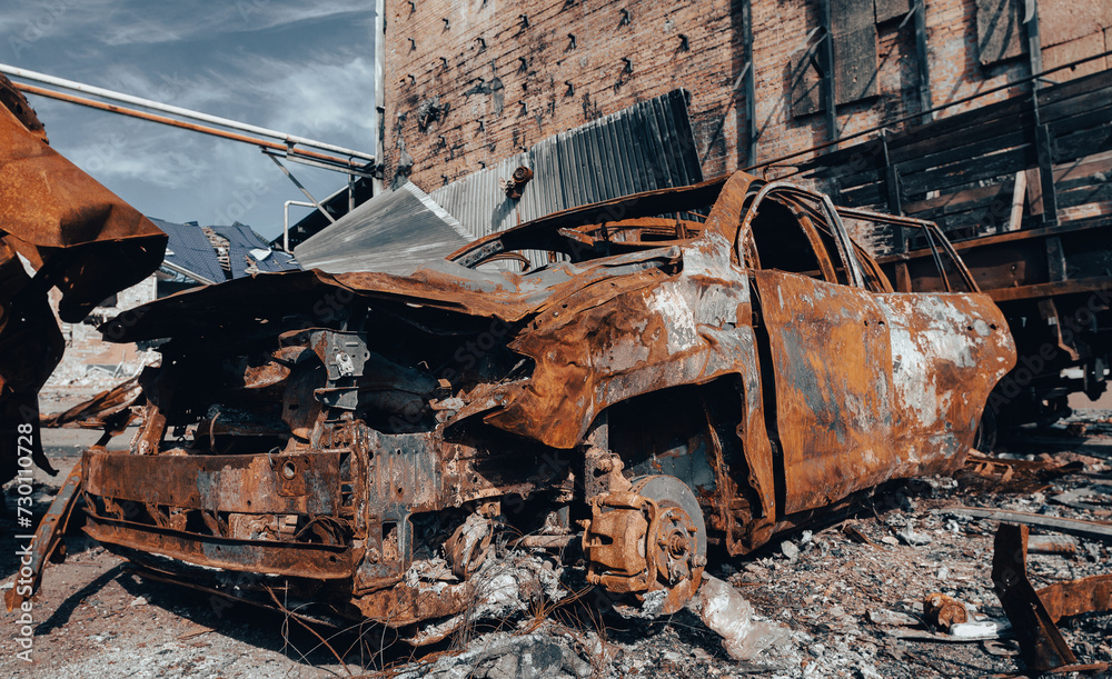 burnt car on the street of the ruined city