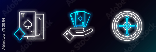 Set line Casino roulette wheel  Playing card with spades and Hand holding deck of playing cards icon. Glowing neon. Vector