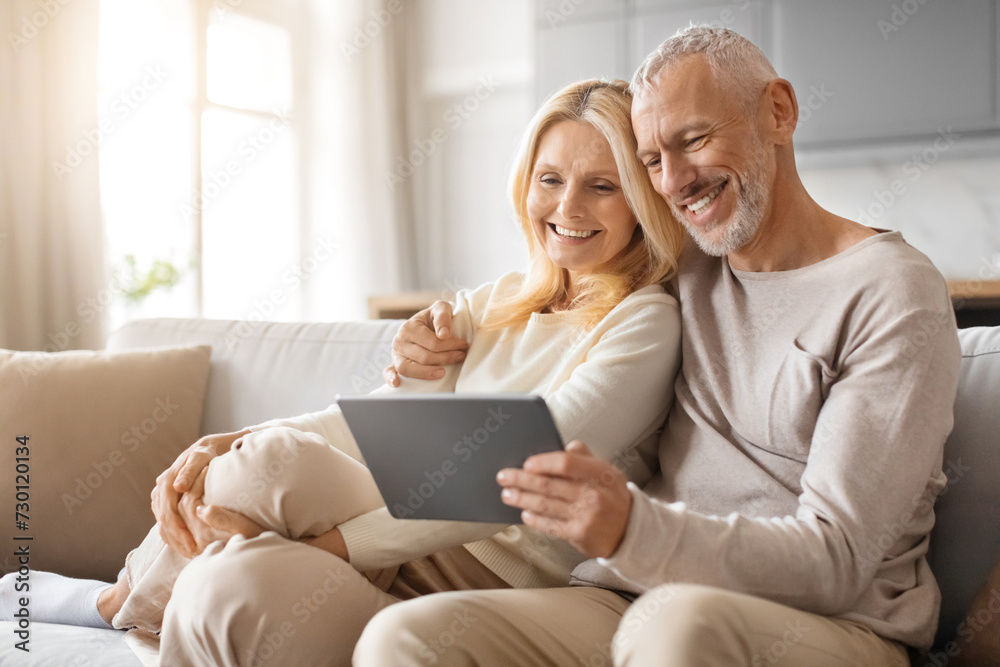 Happy Senior Couple Enjoying Digital Gadget World Using Their Tablet Happy Senior Couple Enjoying Digital Gadget World Using Their Tablet