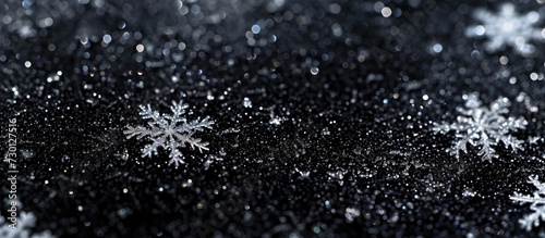 Close-up macro snow texture with snowflakes on black background, suitable for holiday gift cards.