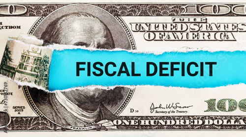 Fiscal Deficit. The word Fiscal Deficit in the background of the US dollar. Government Spending Exceeds Revenue Concept.