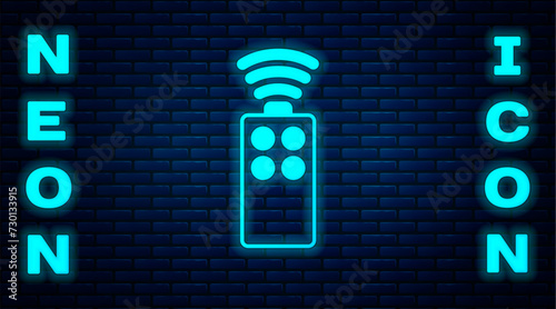Glowing neon Remote control for the camera icon isolated on brick wall background. An auxiliary device that allows you to work with a camera from a distance. Vector