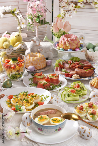 Easter table with traditional white borscht, deviled eggs, salads and pastries
