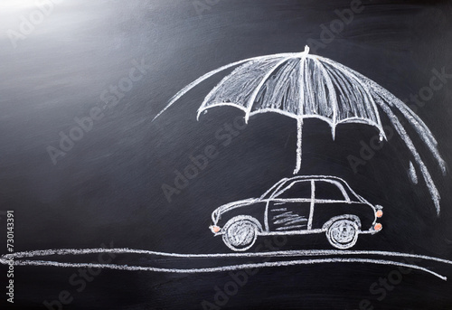 Car and umbrella drawn with chalk on black board.