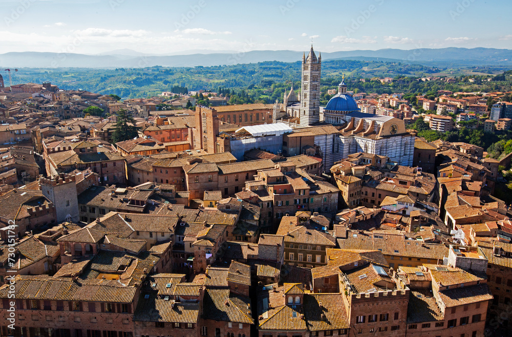 Fototapeta premium Aerial view of the terracotta rooftops of the UNESCO world heritage city of Siena with Siena Cathedral