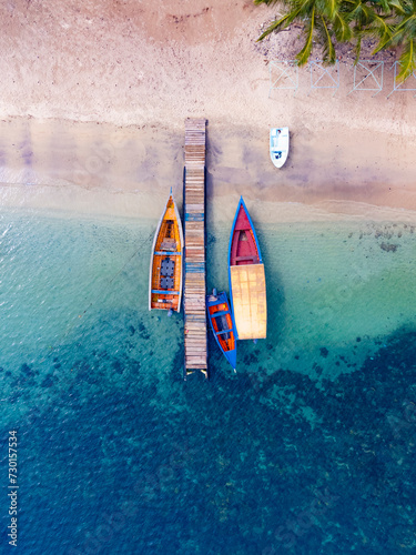 Muelle con botes coloridos en playa con aguas cristalinas  photo