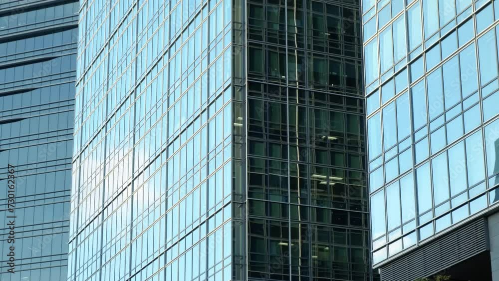 Abstract modern business architecture. Walls made of glass and steel with reflections of buildings and blue sky. Abstract modern business architecture. Walls made of glass and steel with reflections of buildings and blue sky.