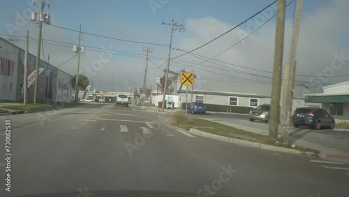 High speed time lapse car front POV 13th Avenue N at 18th Street going west till I275 Bridge in Saint Petersburg, Florida. Daytime on a sunny day  with blue and white sky in industrial area.
