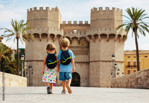Brother and sister walk in front of famous Torres de Serrans