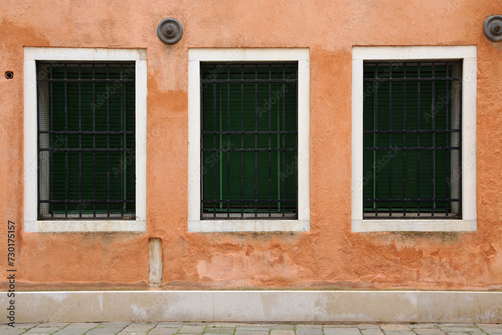 Italy, Venice. Three antique windows in an old house.