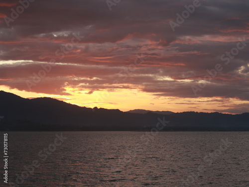 Sunset Over the Lake with Mountains and Clouds in the Background