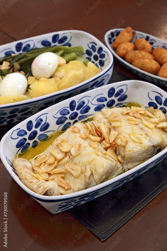 oven-baked cod with thin slices of garlic and olive oil. Served with broccoli, eggs and boiled potatoes