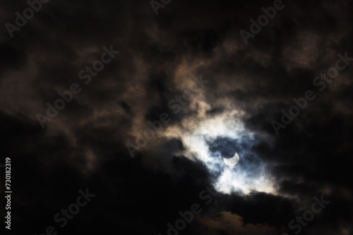 A partial solar eclipse of October 25, 2022 captured through moody dark clouds, the maximal phase visible from Europe, Romania