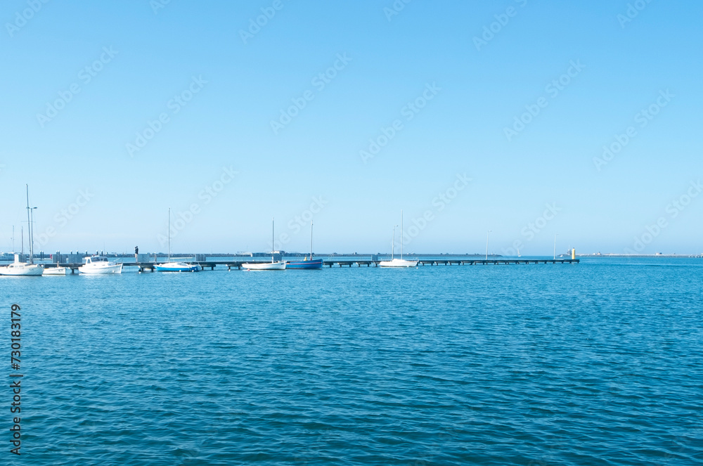 Scenic view of multiple boats in the vast sea