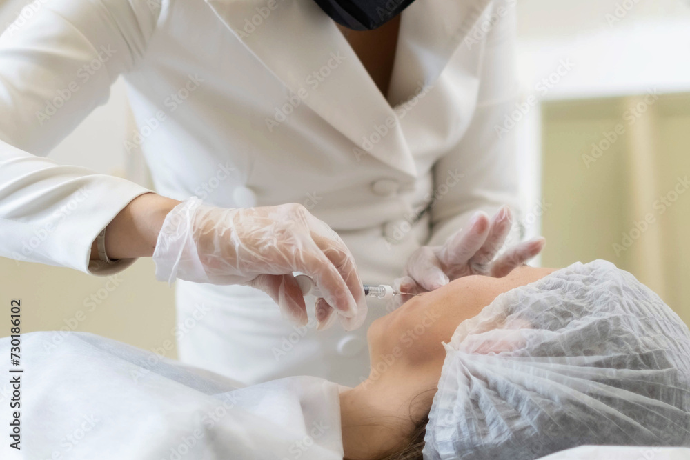 Expert performing a filler injection to smooth out nasolabial folds. A common procedure in the fight against facial wrinkles. Expert performing a filler injection to smooth out nasolabial folds. A common procedure in the fight against facial wrinkles.