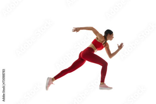 Side view. Athletics. Motivated woman in motion, running, training against white studio background. Tournament. Concept of sport, active and healthy lifestyle, sportswear, competition