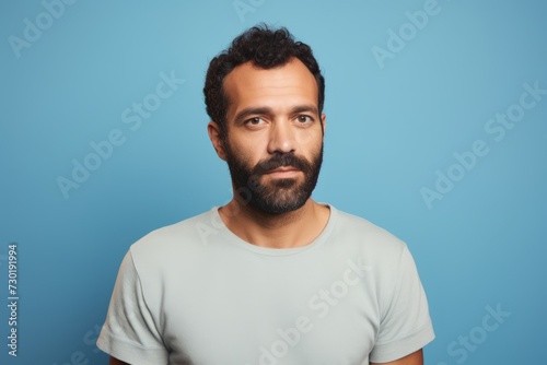 Portrait of handsome bearded man in casual t-shirt on blue background