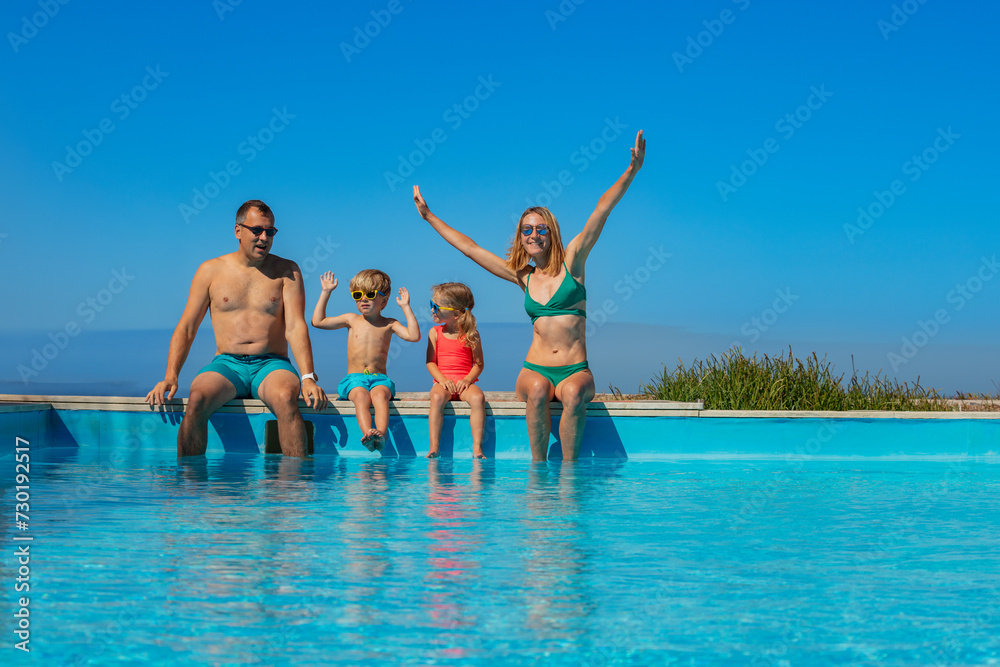 Parents with kids take pleasure to sit on the edge of pool Parents with kids take pleasure to sit on the edge of pool