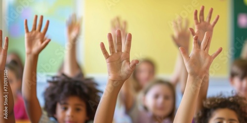 Group of school children raising their hands in a classroom. Selective focus.