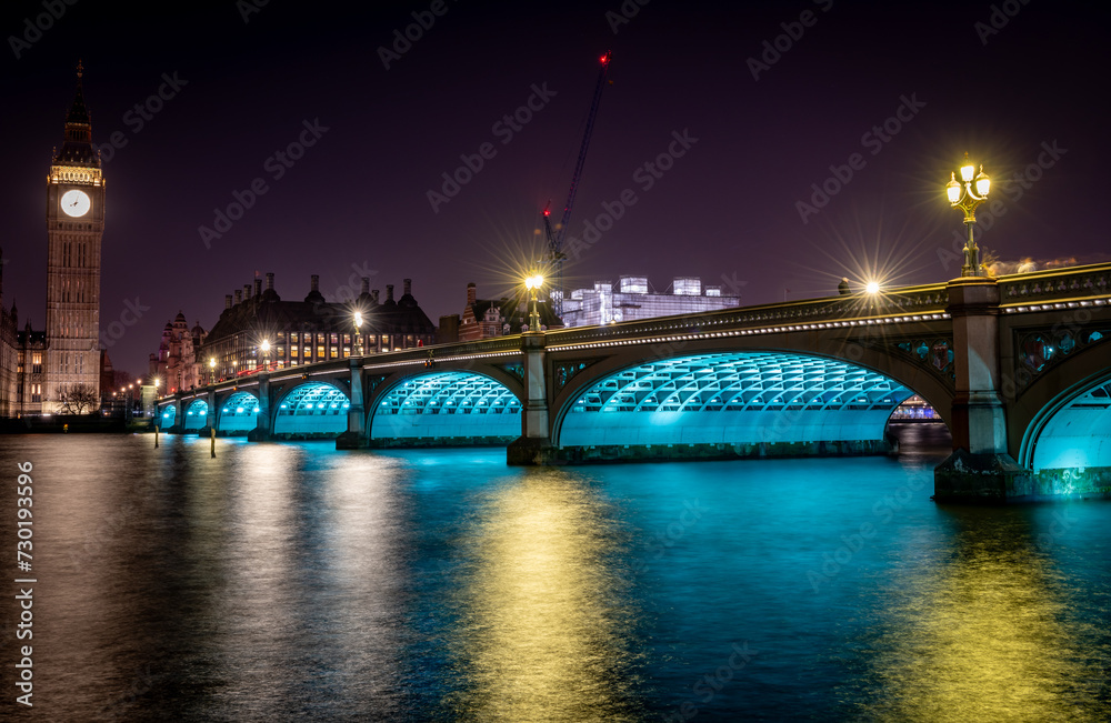 London. UK- 02.04.2024. A night time long exposure view of Westminster Bridge with Big Ben at the end and light reflections on the River Thames.