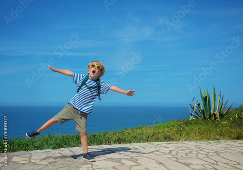 Excited blond boy shouting and dancing celebrating vacations