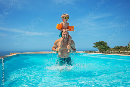 Joyful pool day with child piggybacking on fathers shoulders