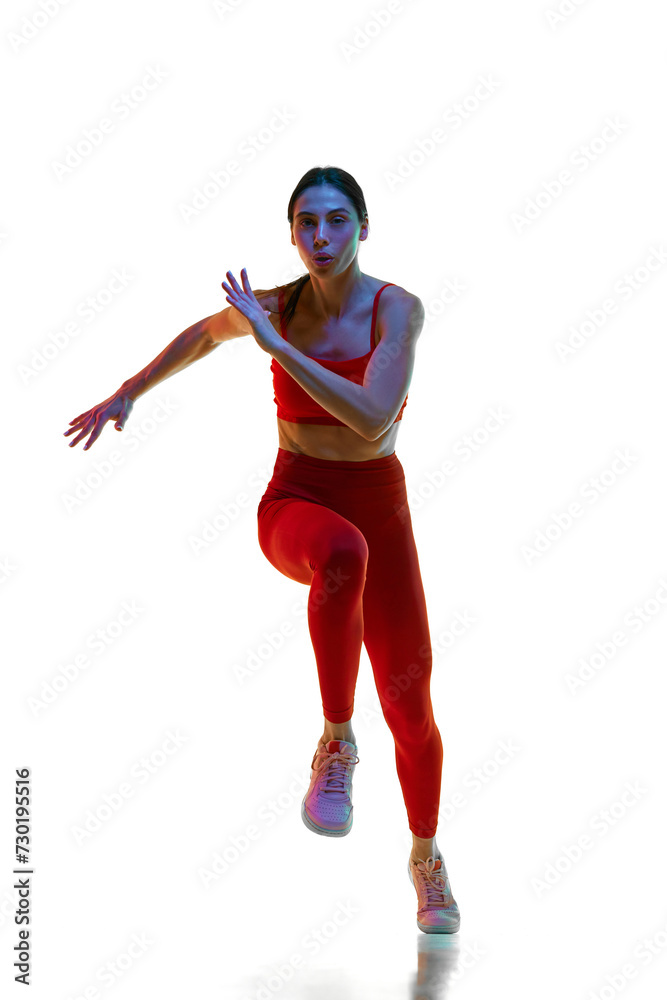Sportive motivation. Athletics. Female athlete, runner in motion, training against white studio background in neon light. Concept of sport, active and healthy lifestyle, sportswear, competition