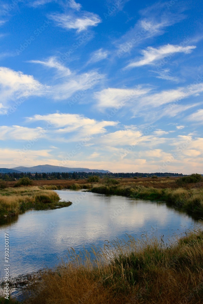 Wood River Wetland with blue sky, reflection in water and mountains in background, Chiloquin, Oregon
