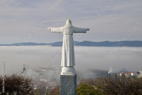 Statue on Santa Barbara Hill in Favaios with panoramic views above the clouds.