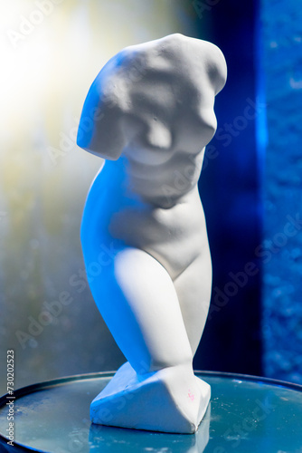 close-up white sculpture in the form of a body standing on a barrel museum exhibit performance art