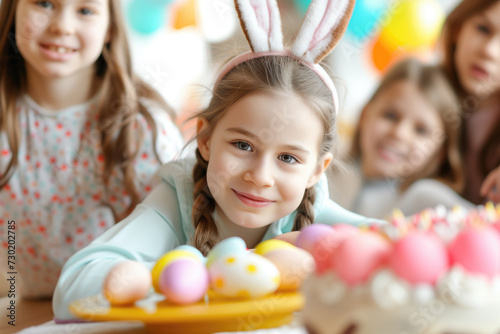 Portrait of girls celebrating Easter with colored eggs and cake at home