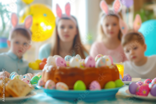 Family celebrating Easter at dinner table with colored eggs and Easter cake
