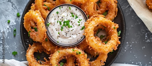 Vegan-style onion rings with dip, from a top view.