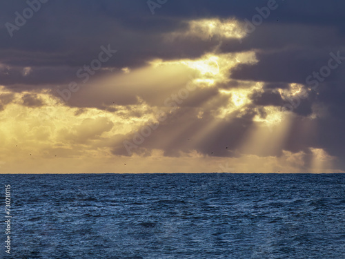 Cloudy seascape with sunbeams at sunseat