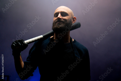 bald brazen robber with beard holding baseball bat during robbery attack crimes threats photo