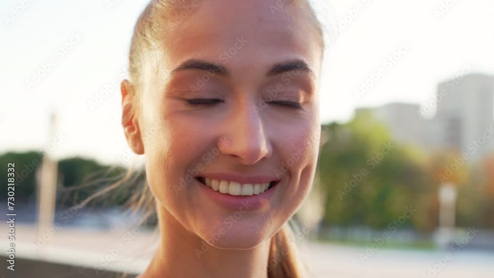 Closeup portrait of beautiful young woman smiling at camera and then looking sideways. Relaxed fit sporty female against blurred background in city during daytime. Closeup portrait of beautiful young woman smiling at camera and then looking sideways. Relaxed fit sporty female against blurred background in city during daytime.
