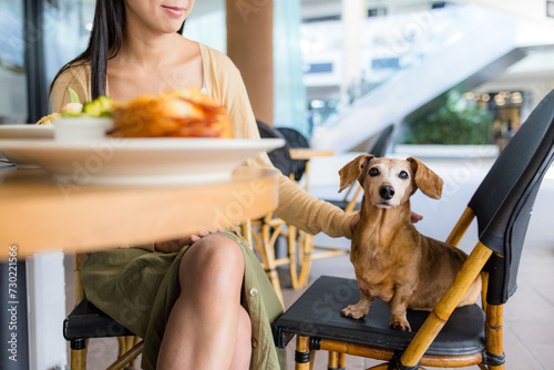 Woman go to restaurant with her dog in shopping center