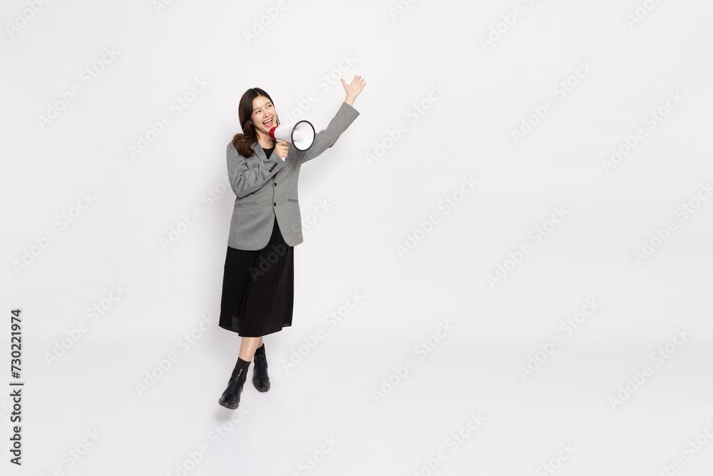 Young Asian businesswoman in grey suit smile and holding megaphone isolated on white background, Wow and Announce Speech concept Young Asian businesswoman in grey suit smile and holding megaphone isolated on white background, Wow and Announce Speech concept