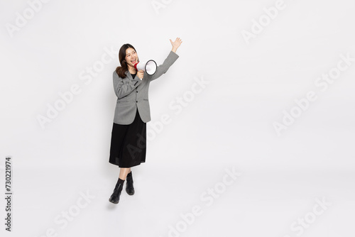 Young Asian businesswoman in grey suit smile and holding megaphone isolated on white background, Wow and Announce Speech concept