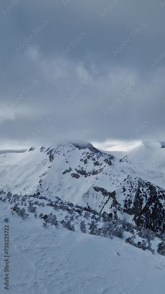 Winter mountain peaks covered by fluffy snow clouds, beautiful aerial view Winter mountain peaks covered by fluffy snow clouds, beautiful aerial view