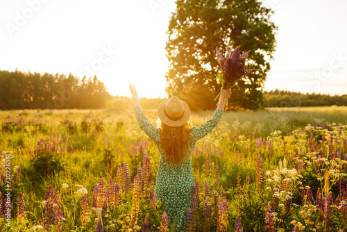 Beautiful woman stands  on blooming fragrant lavender fields. Nature, vacation, relax and lifestyle. Collection of medicinal herbs