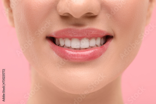Woman with clean teeth smiling on pink background  closeup
