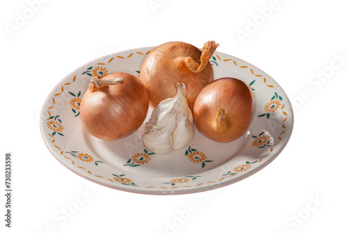 Ail et oignons dans une vieille assiette décorée