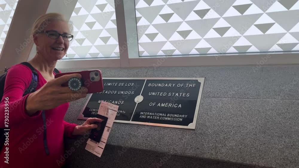 Woman taking a selfie of her in front of the Mexico USA border in the ...