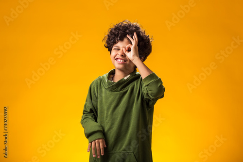 Smiling child boy showing ok gesture. Positive emotions concept